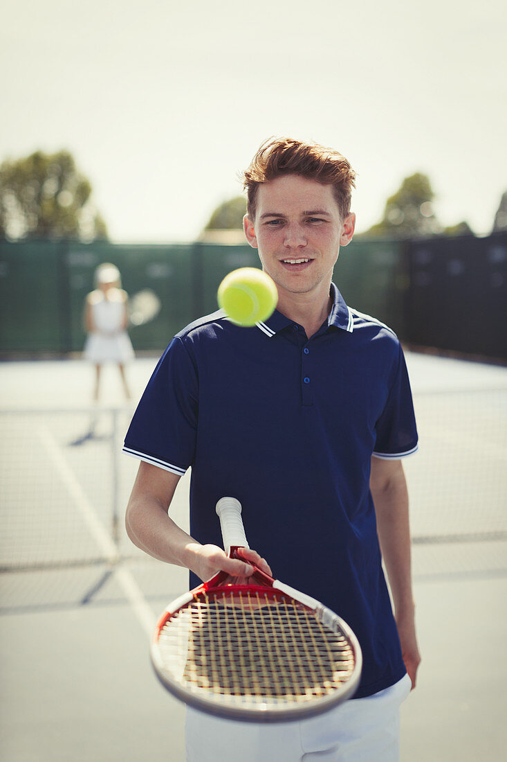Tennis player bouncing tennis ball on racket