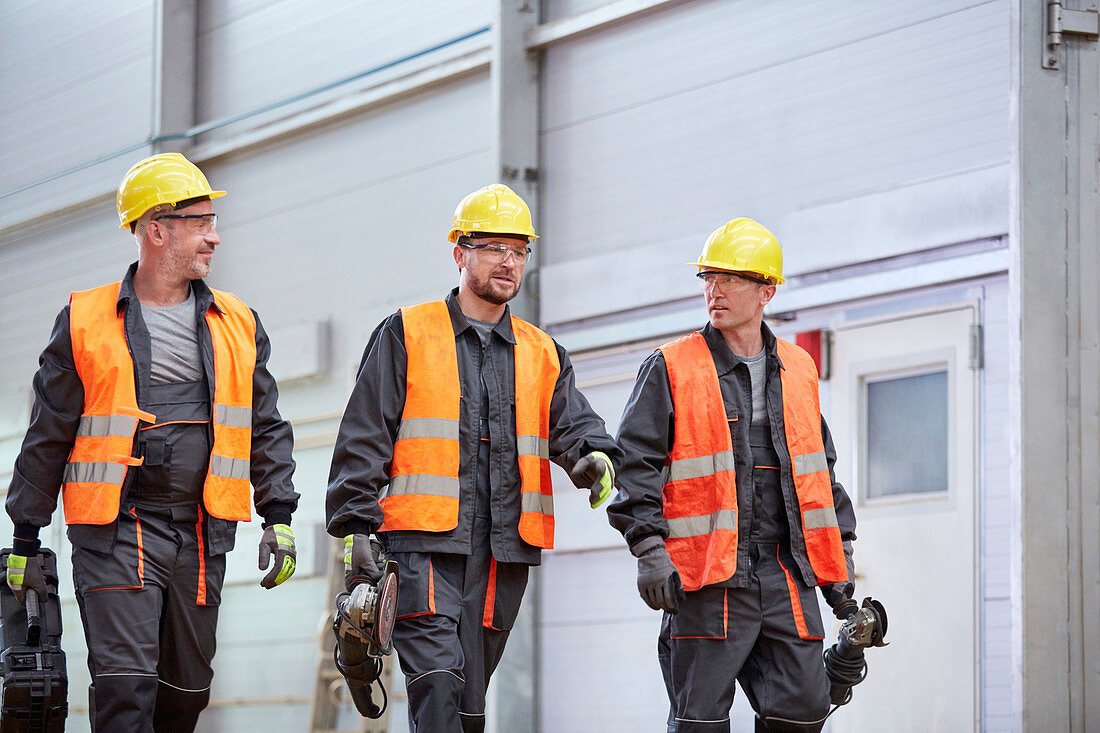 Male workers in protective clothing walking
