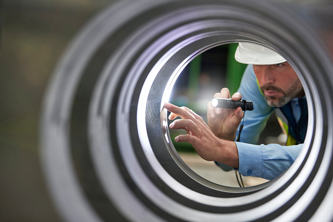 Male engineer inspecting steel cylinder
