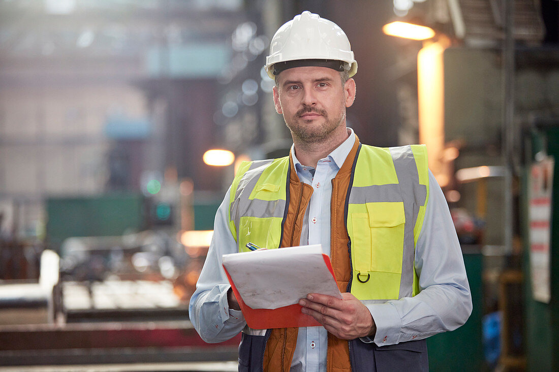 Portrait male foreman with clipboard in factory