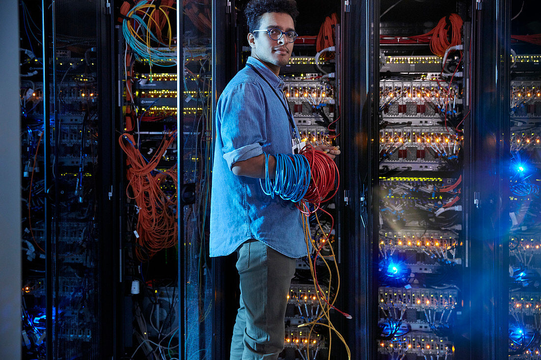 Portrait male IT technician holding cables