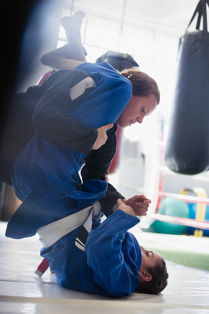 Women practicing jiu-jitsu in gym