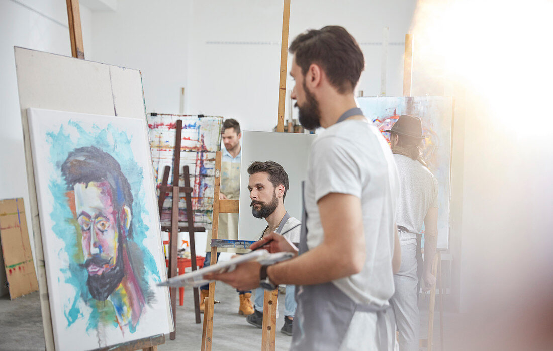 Artists painting at easel in art studio
