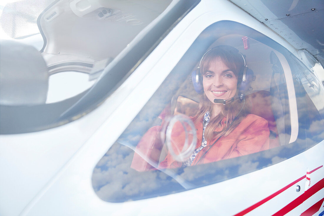Portrait female airplane pilot in cockpit