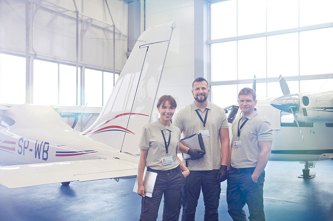 Mechanic engineers standing in airplane hangar
