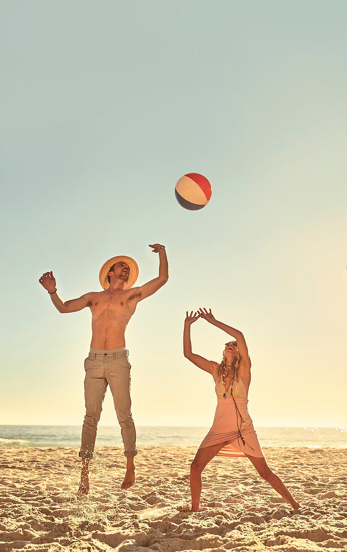 Young couple playing with beach ball