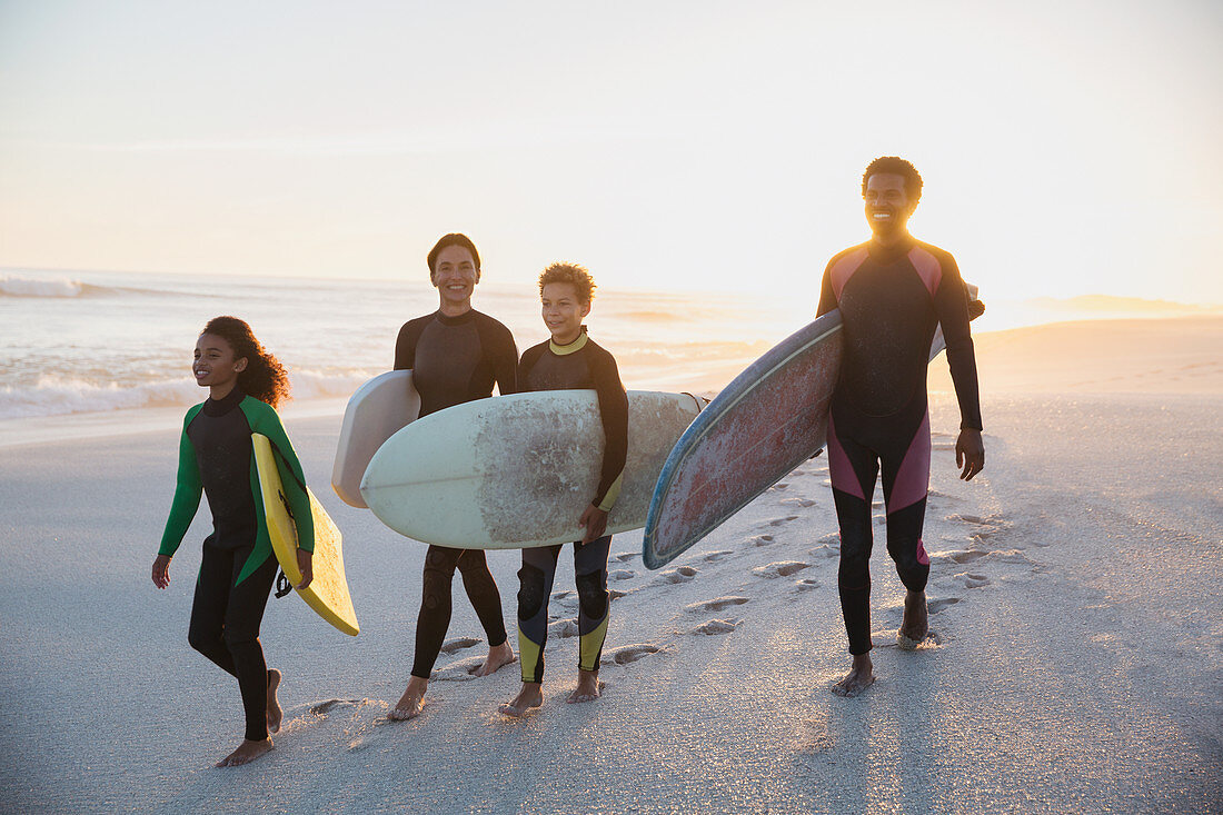 Family surfers carrying surfboards