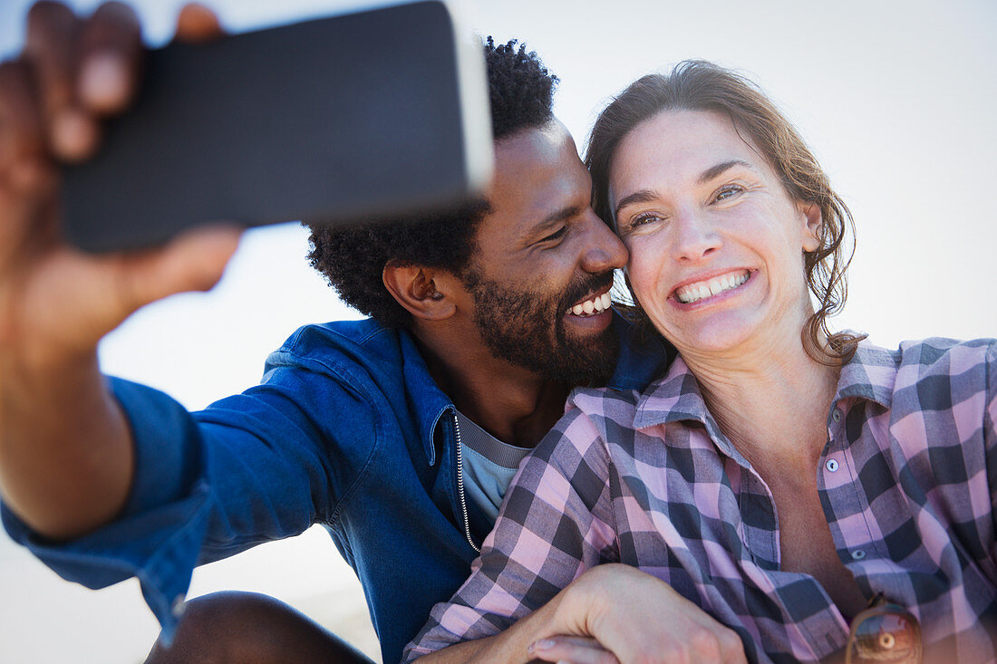 Smiling, enthusiastic couple taking selfie