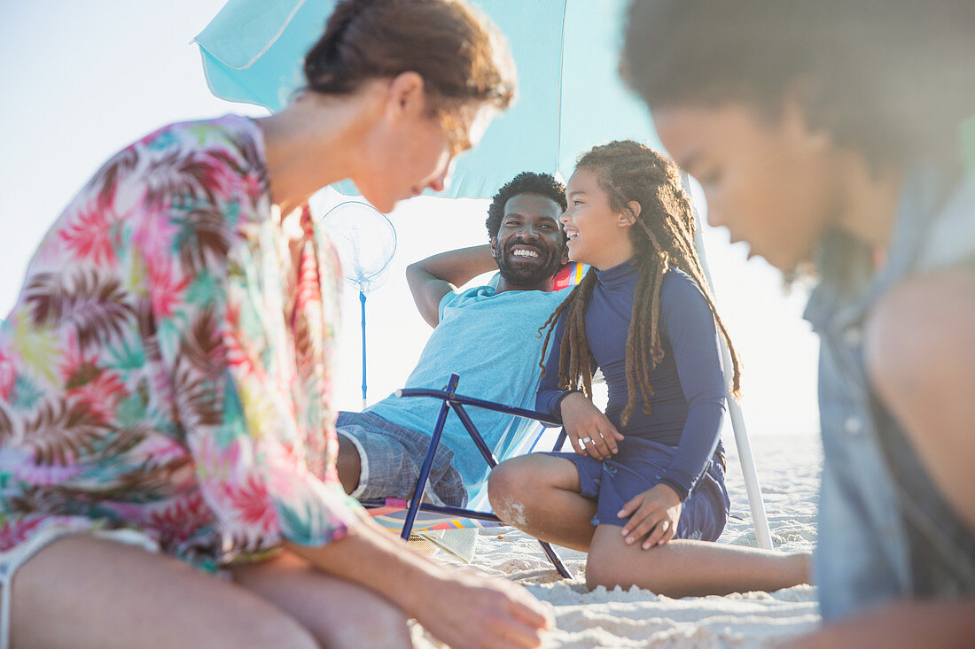 Family relaxing on sunny summer beach