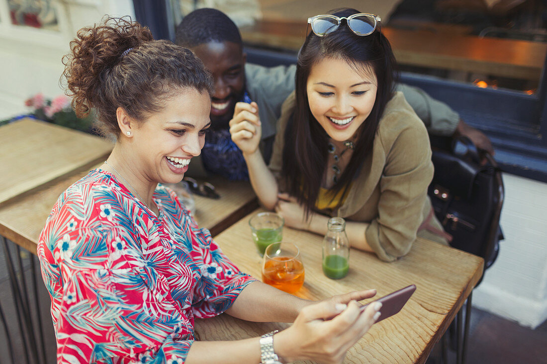 Young women friends using smart phone