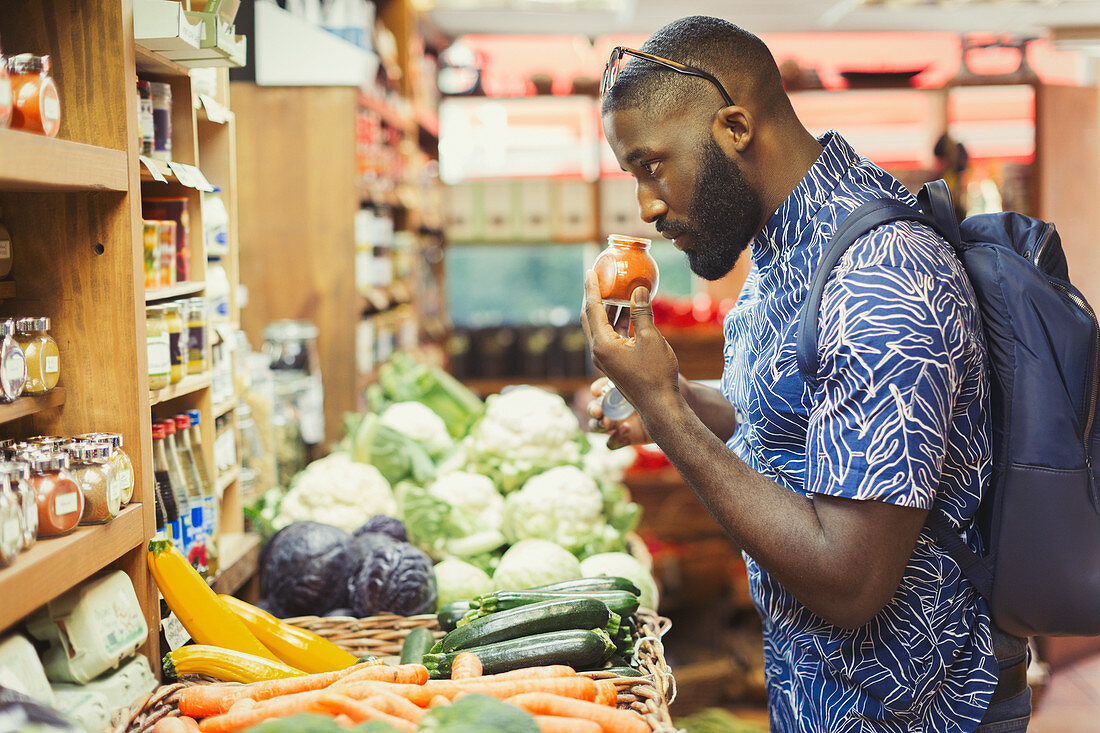 Man shopping, smelling spices in grocery store