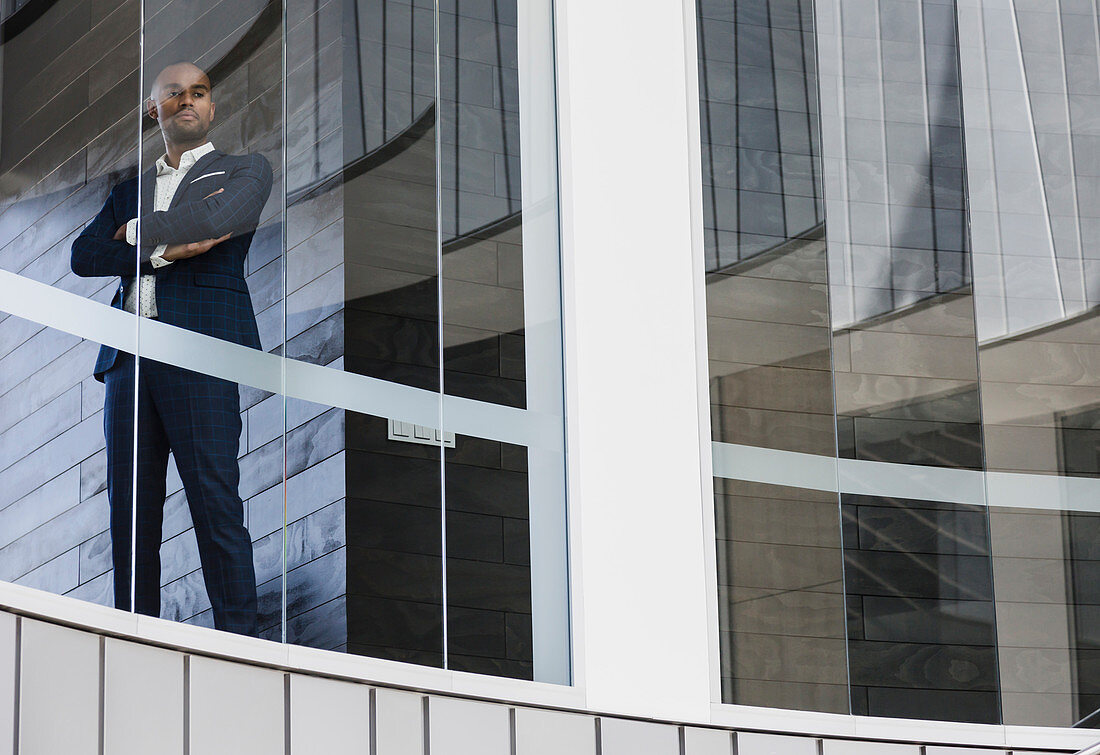 Portrait confident CEO businessman standing window