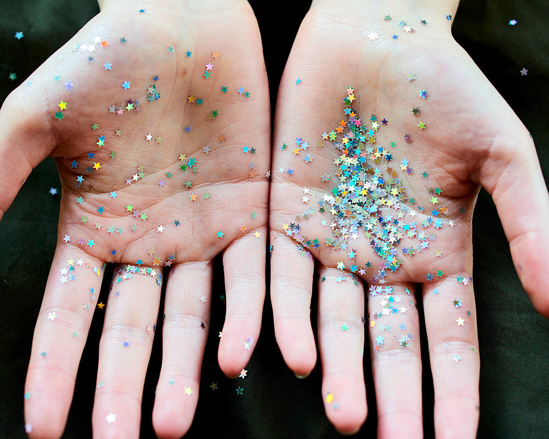 Star confetti glitter on hands