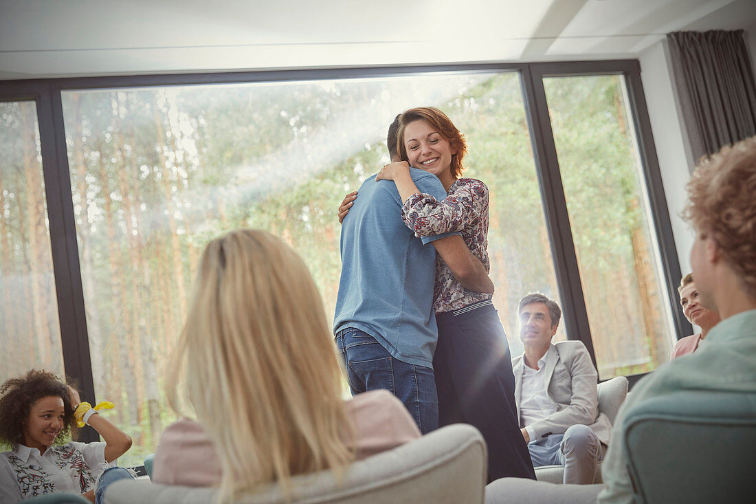 Man and woman hugging in group therapy session