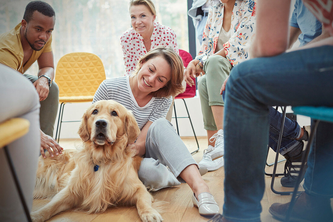 Woman petting dog in group therapy session