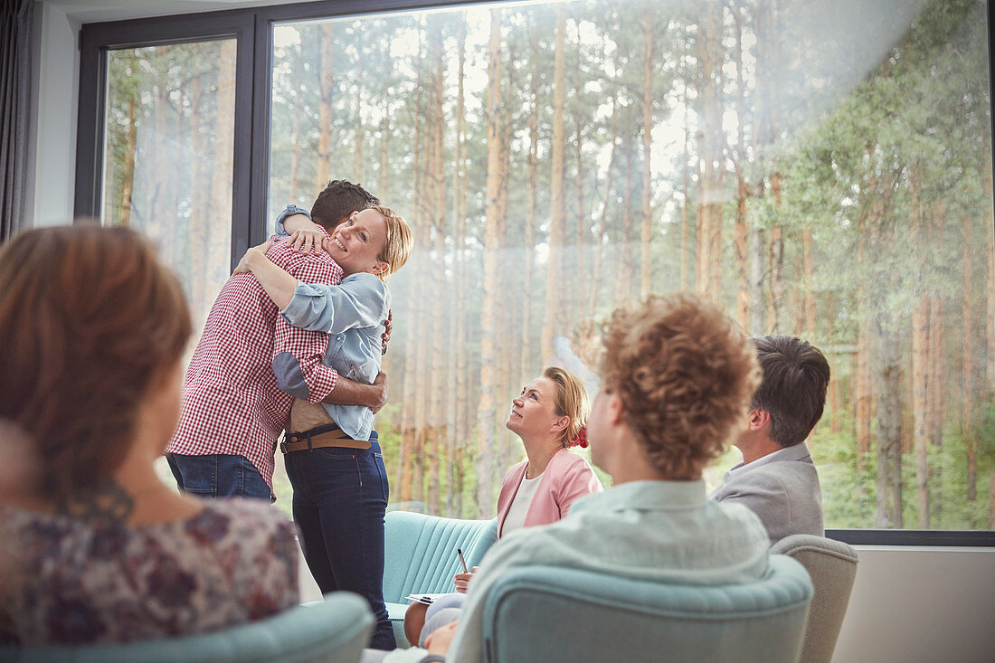 Man and woman hugging in group therapy session