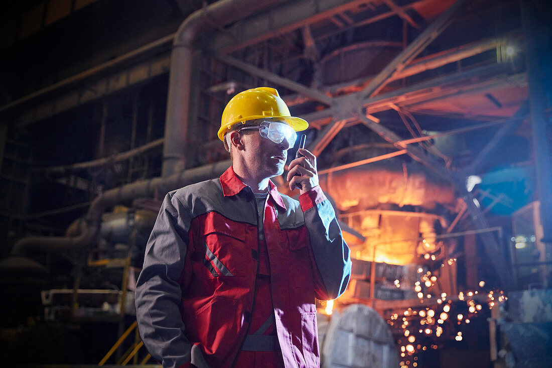 Steelworker talking, using walkie-talkie