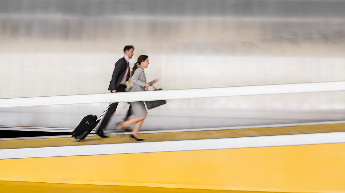 Business people running up airport ramp