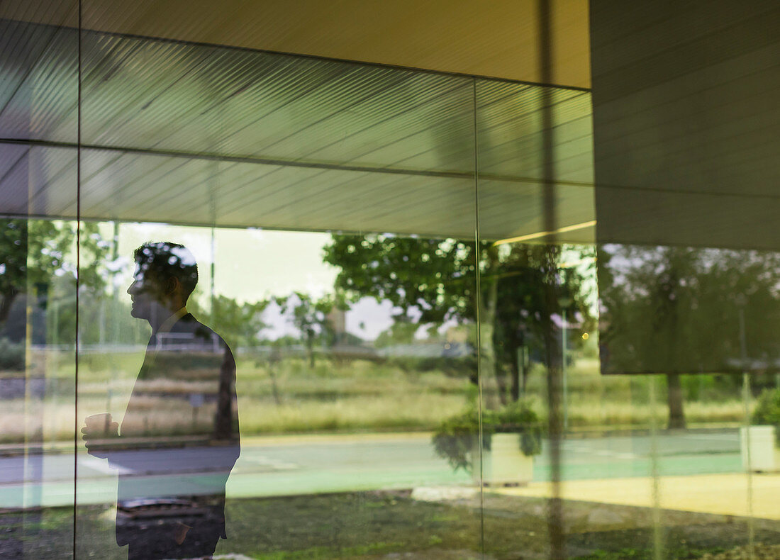 Businessman looking out modern office window