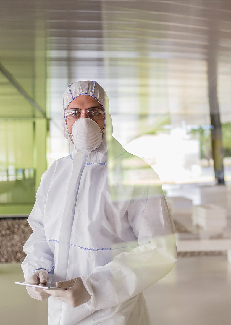 Portrait scientist in clean suit using tablet