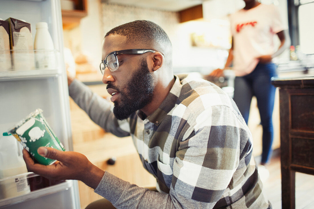 Young man reading label on container