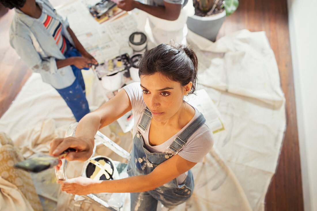 Young woman painting living room