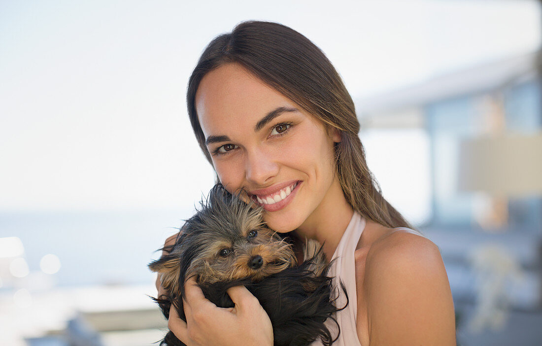 Smiling woman cuddling small dog