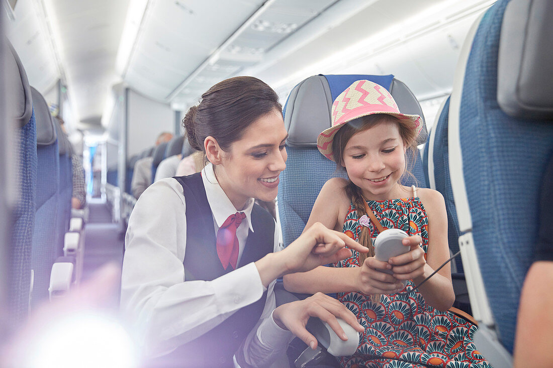 Flight attendant helping girl passenger