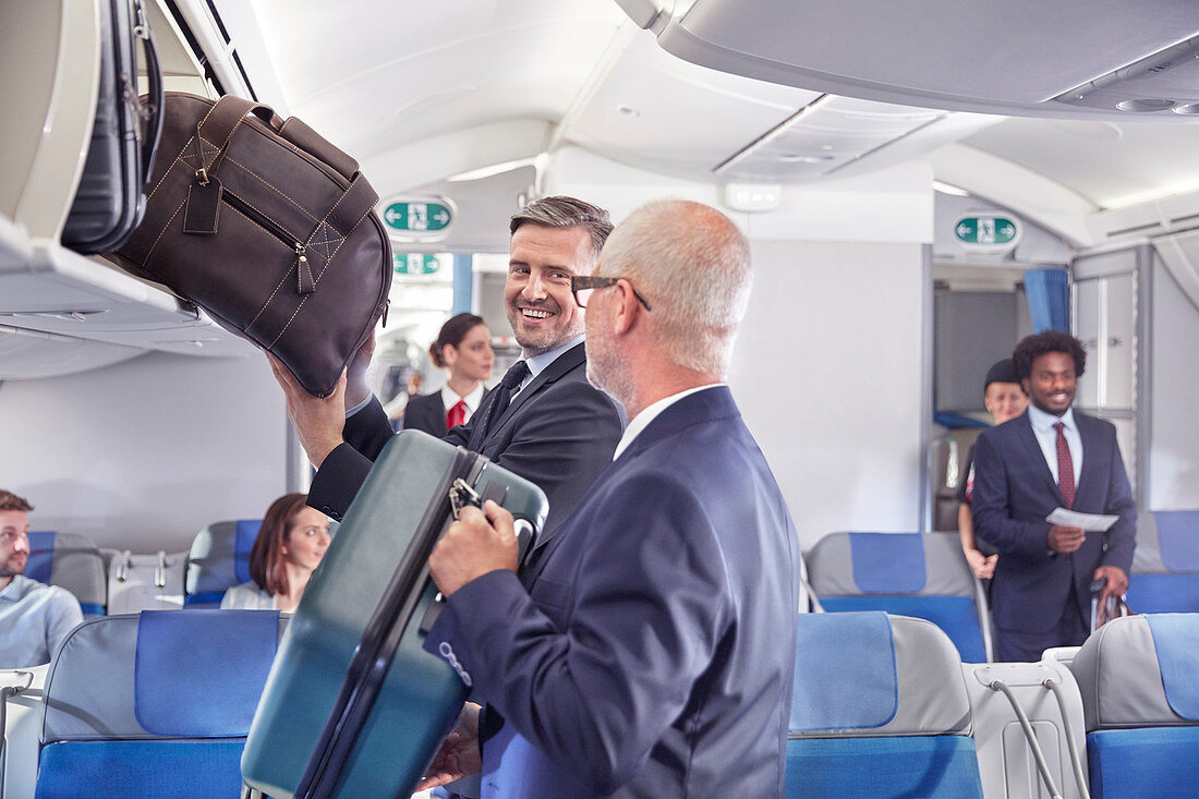 Businessmen loading luggage into storage