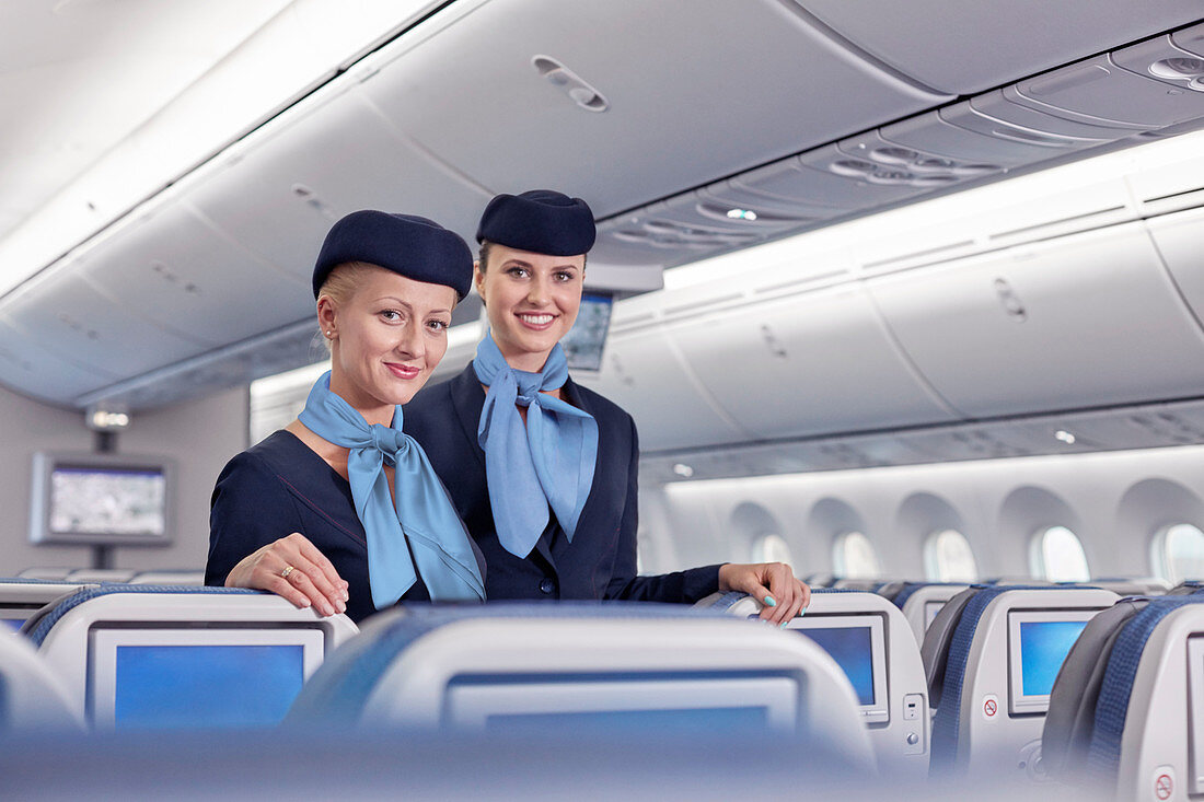Portrait female flight attendants on airplane
