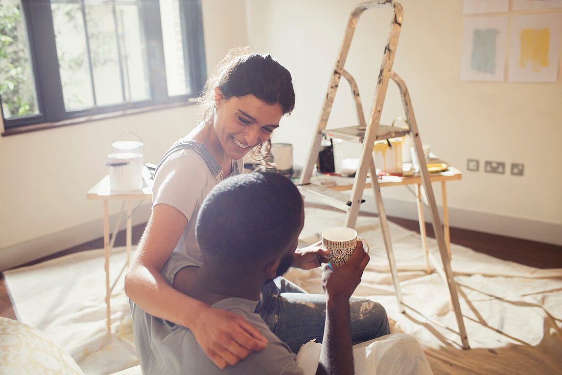 Affectionate couple painting living room