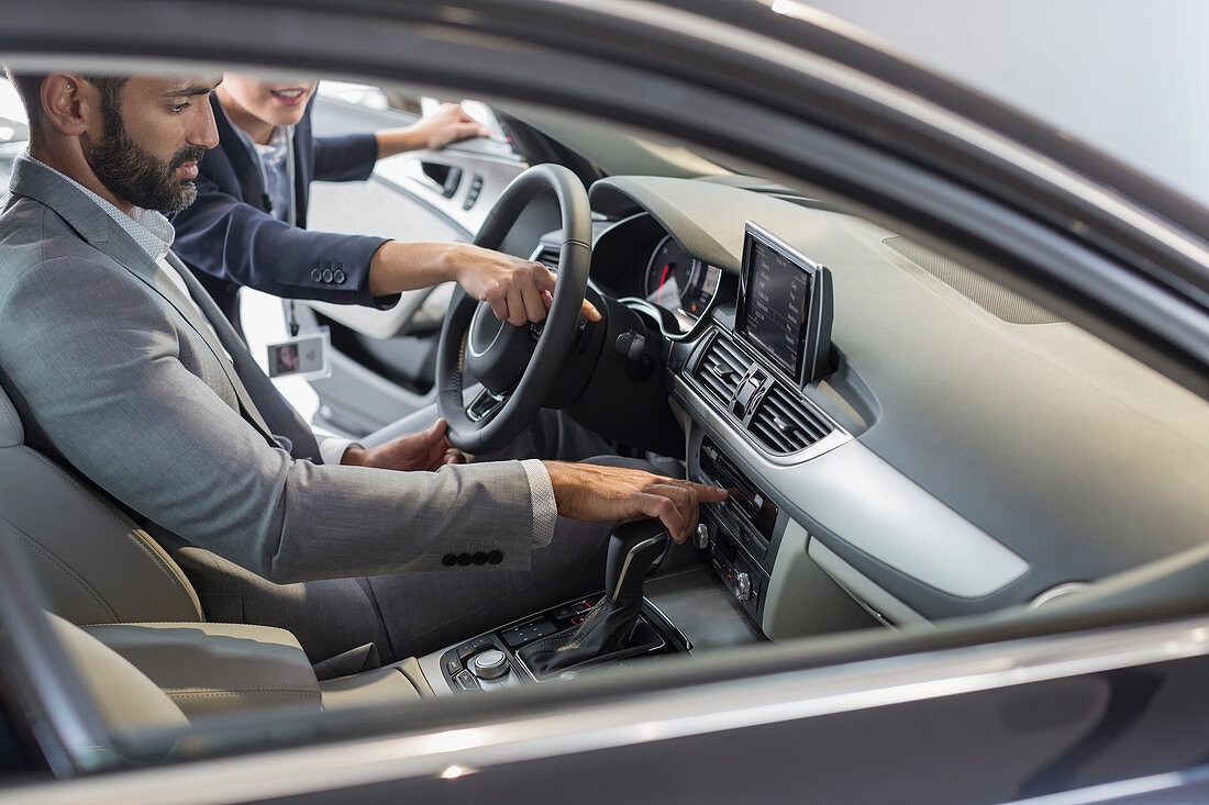 Car saleswoman and customer in driver's seat