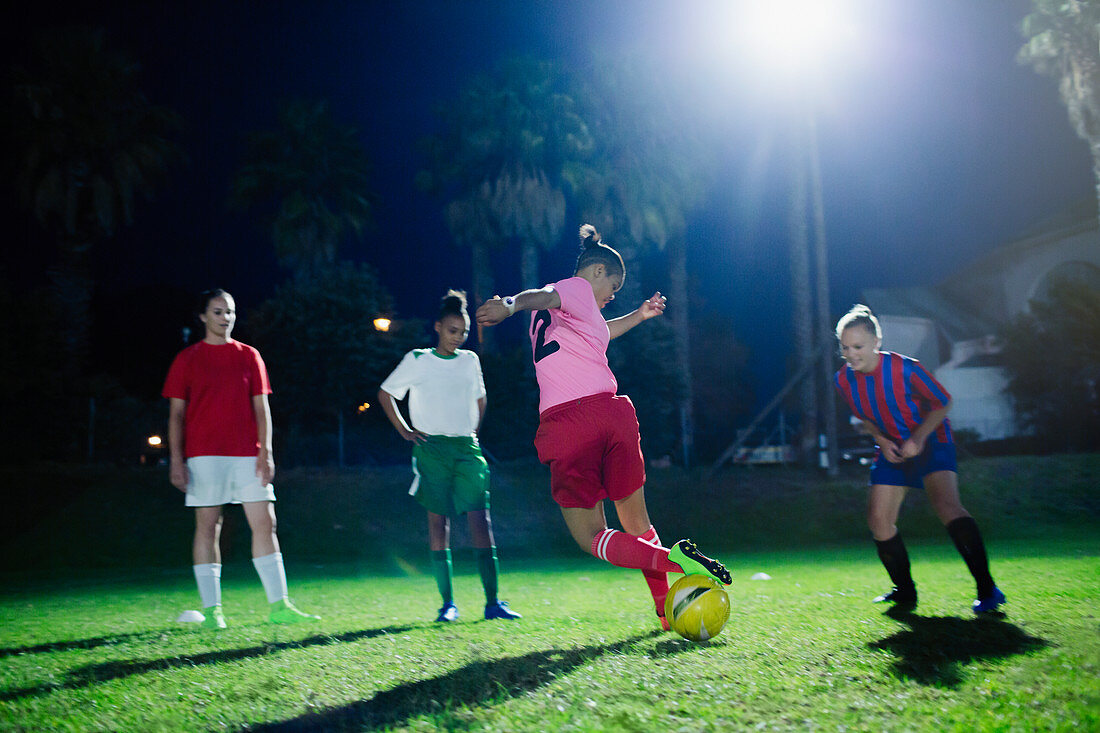 Young soccer players practicing at night