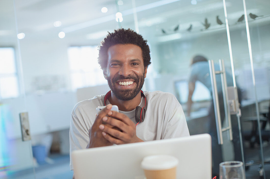 Portrait Businessman using smartphone at laptop