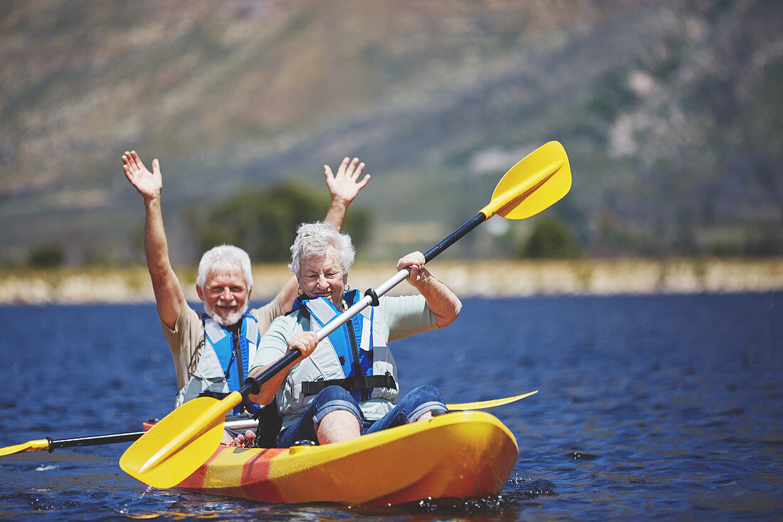Playful, energetic active senior couple kayaking