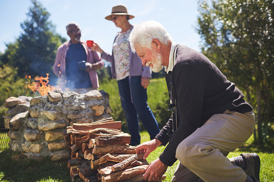 Active senior man stacking firewood