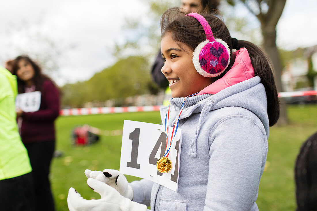 Smiling girl runner wearing earmuffs