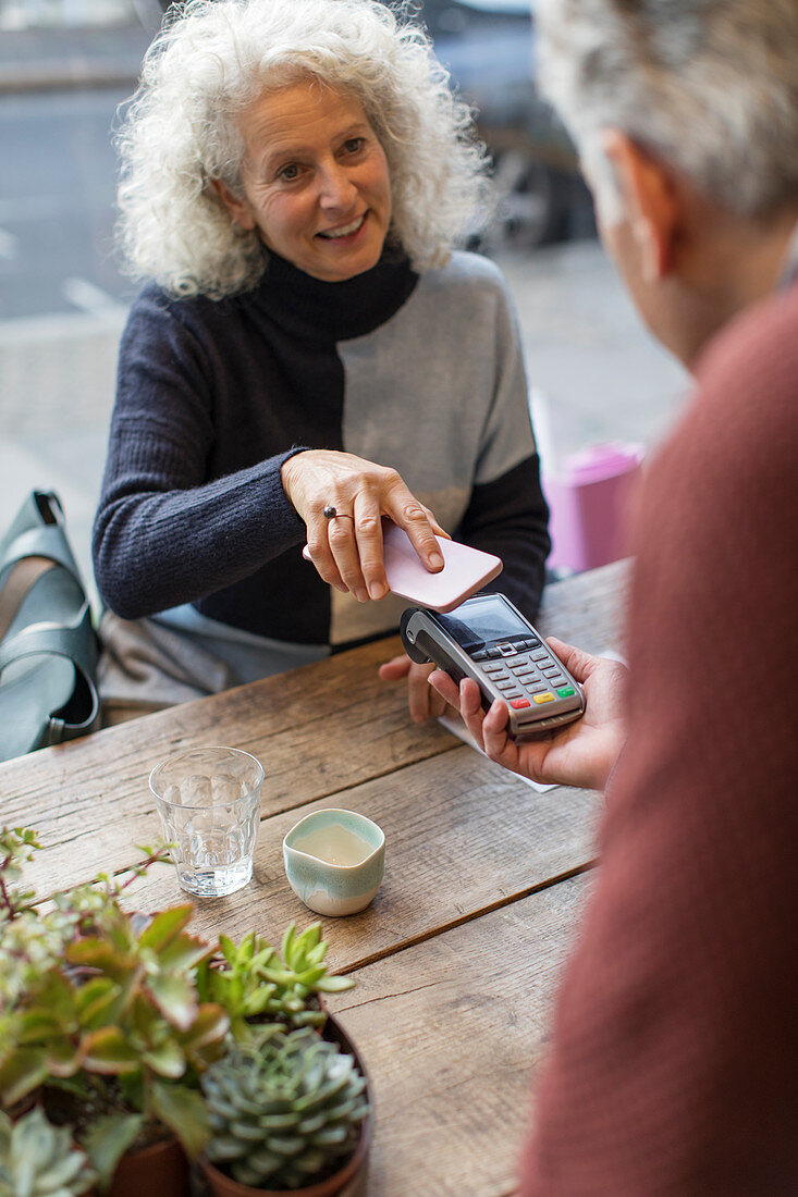 Woman using smart phone contactless payment