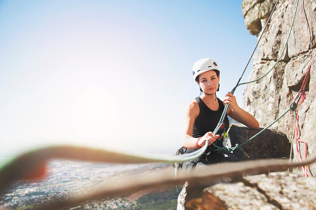 Portrait confident female rock climber with ropes