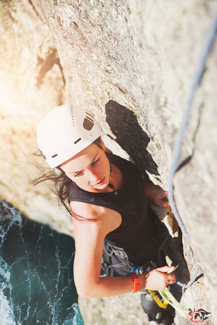 Determined, focused rock climber scaling rock