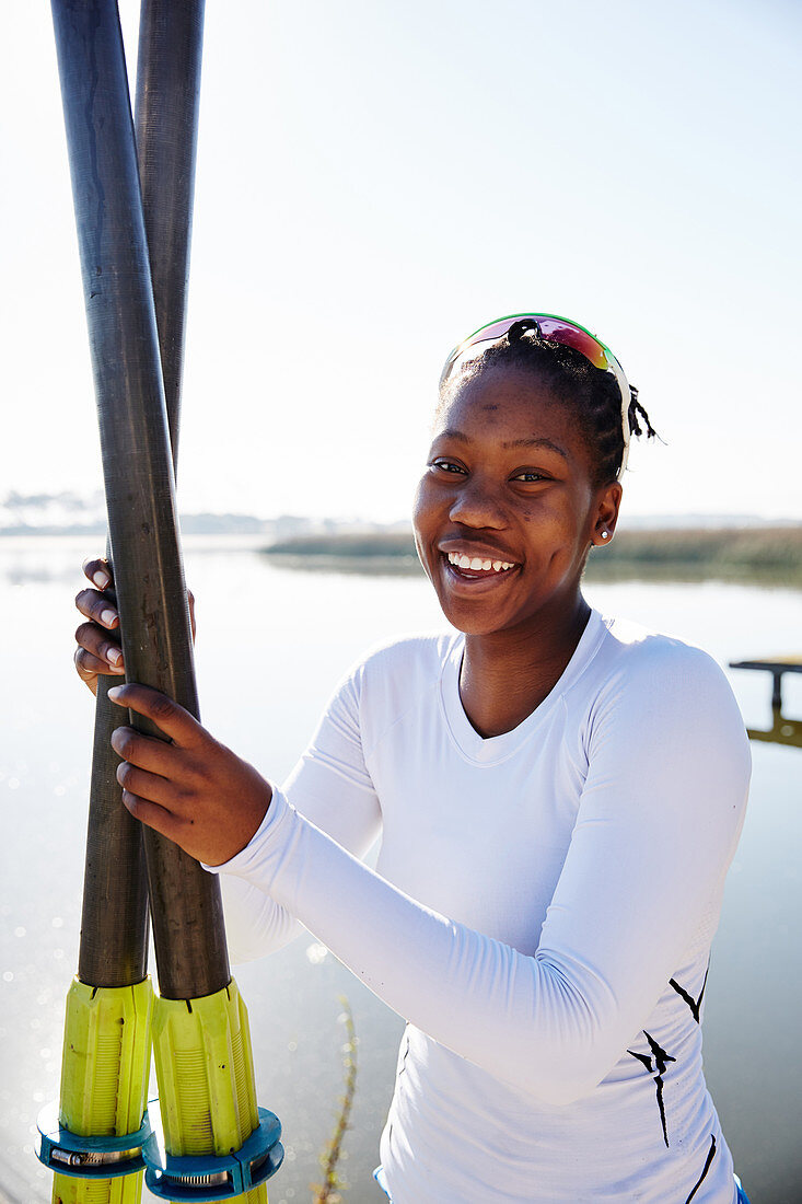 Portrait smiling rower holding oars