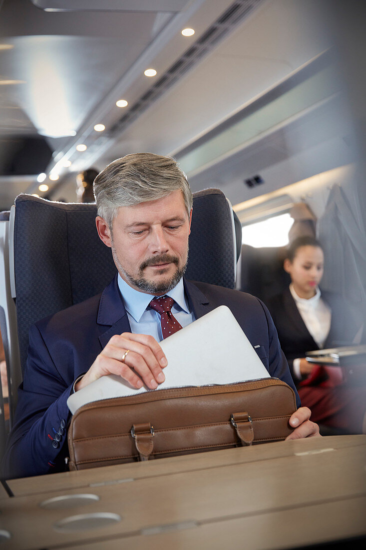 Businessman removing laptop from briefcase