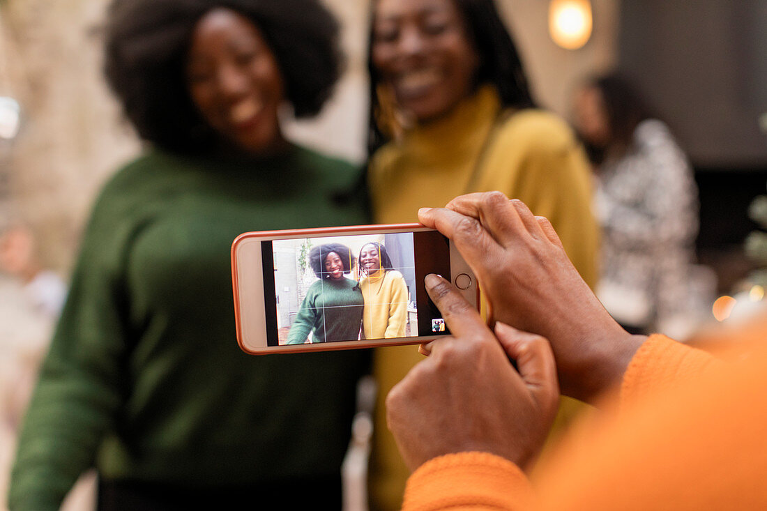 Woman photographing mother and daughter