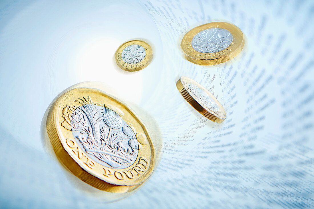 One pound coins surrounded by stock market data