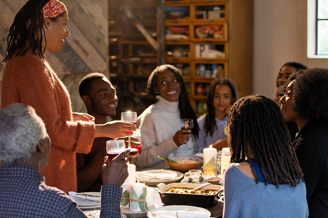 Woman toasting family at Christmas dinner table