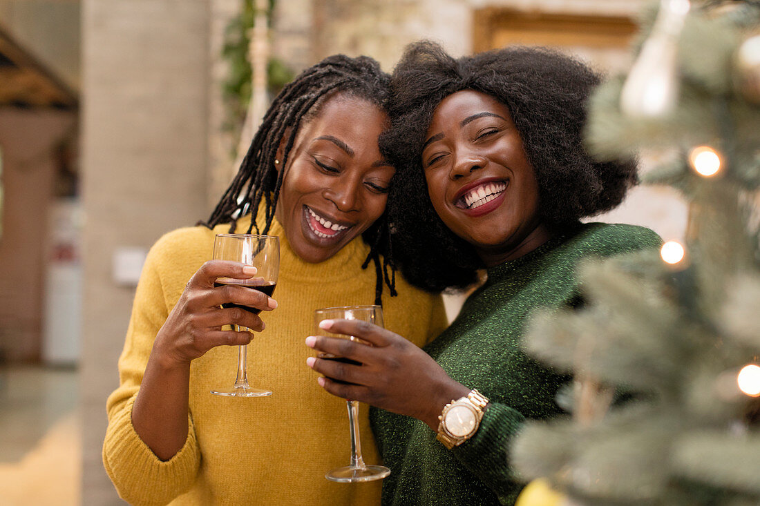 Mother and daughter hugging, drinking wine