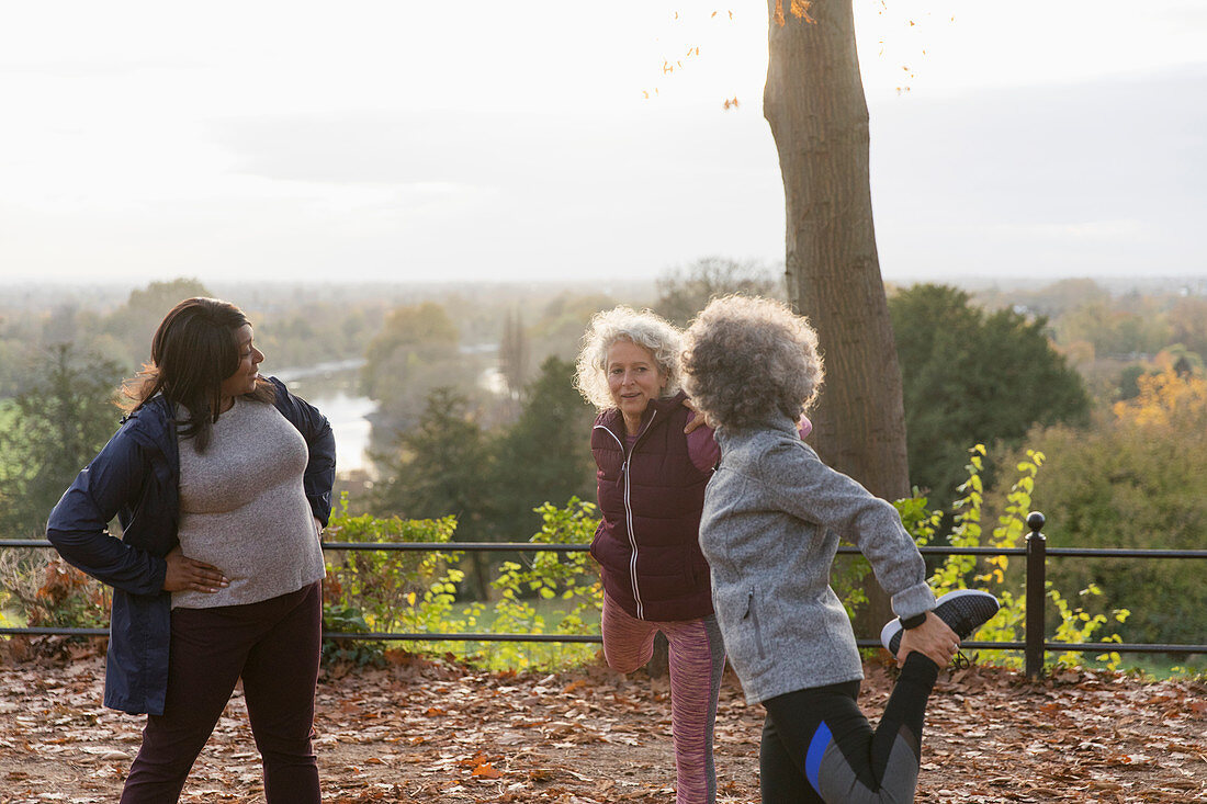 Active senior women friends stretching legs