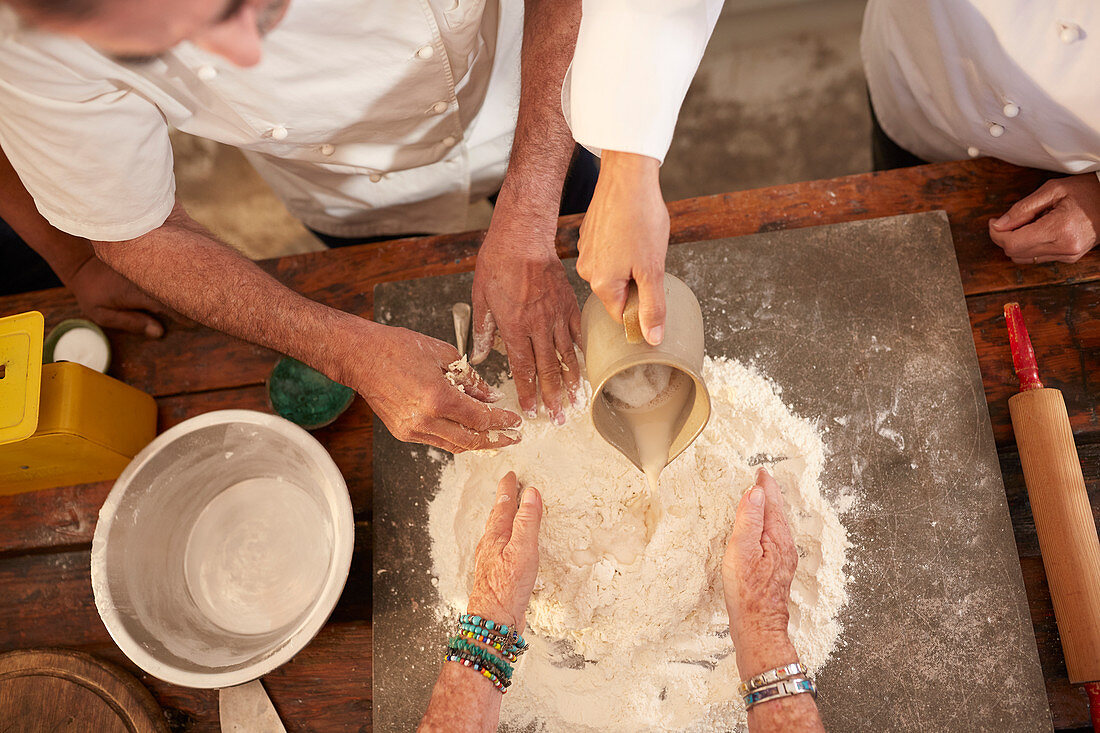 Overhead view chefs making pizza dough flour nest