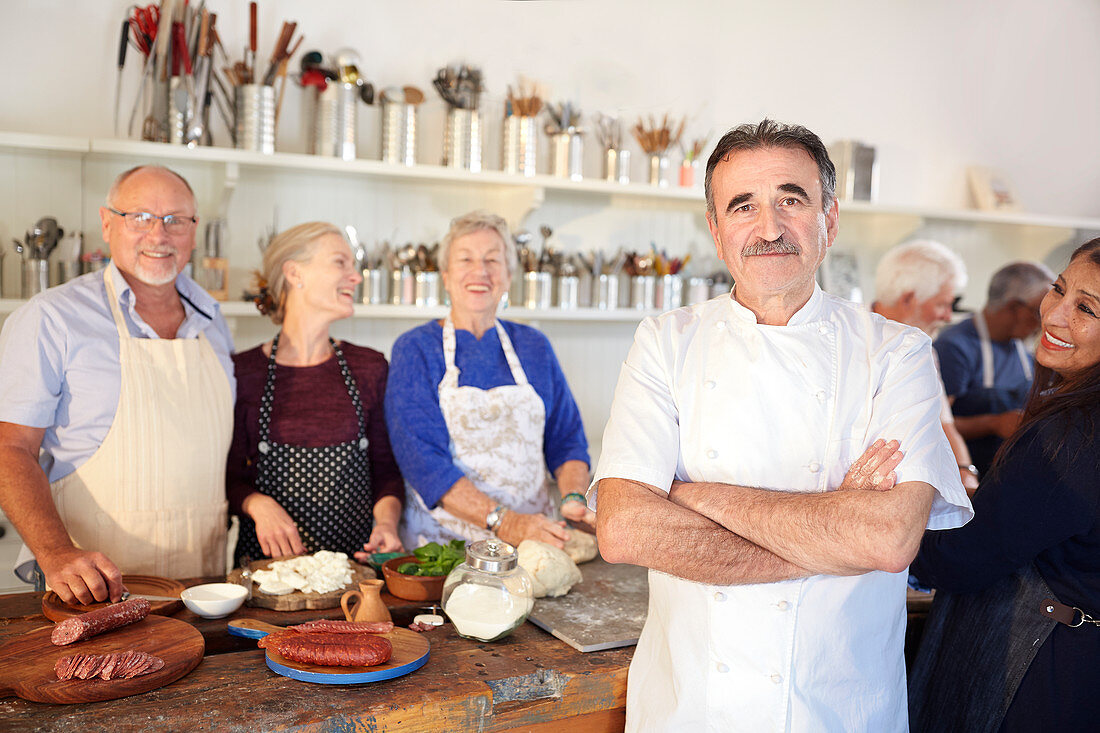 Portrait chef with senior students kitchen