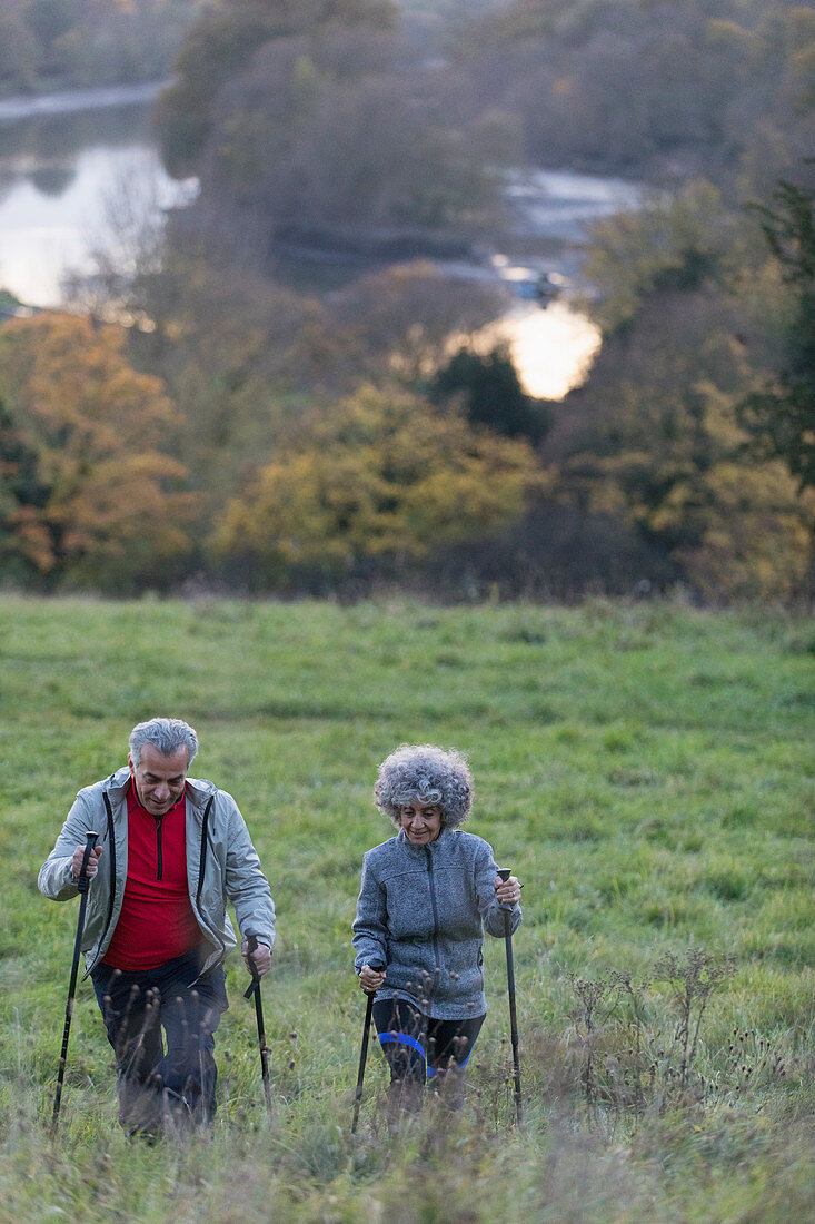 Active senior couple hiking up rural hillside